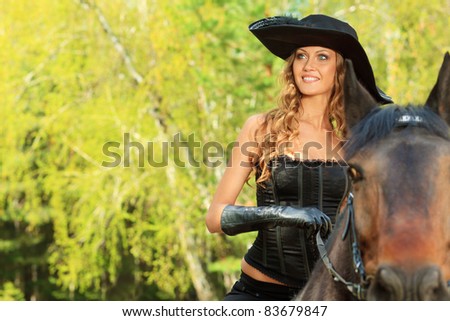 Beautiful young woman in medieval costume is riding on horseback.