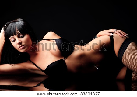Shot of a sexy woman in black lingerie over black background.