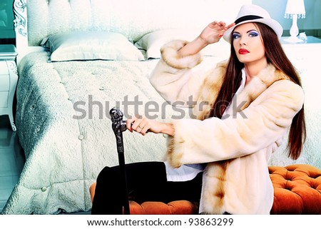 An attractive fashionable woman posing in the interior.