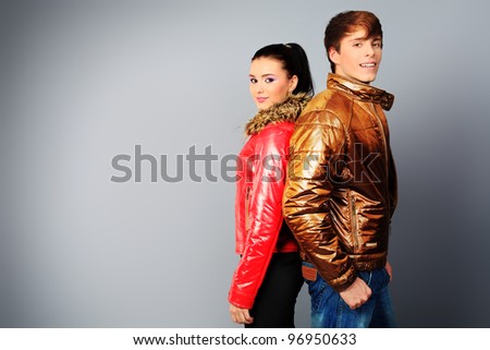 Couple of fashion models in winter, spring clothes posing at the studio.