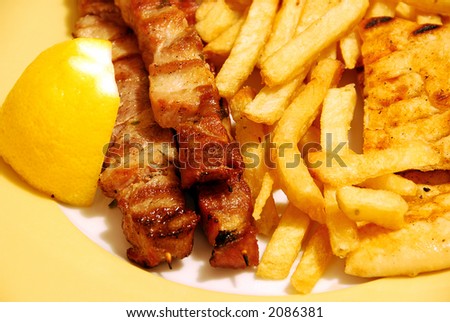 chicken kebabs on plate with fries and pitta bread