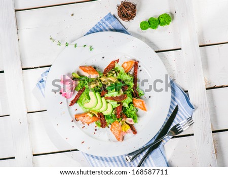 Salad with fried salmon, avocado and smoked tomatoes