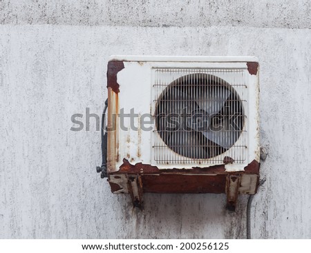 Old rusty air conditioner outdoor unit on house facade