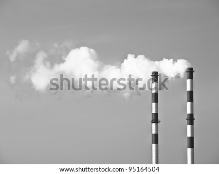 Two smoking chimneys pollution air, black and white monochrome
