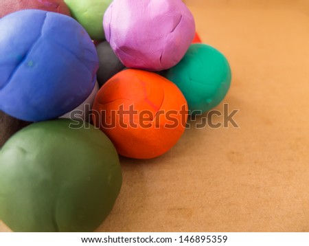 color plasticine balls on brown paper background