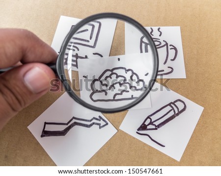 Magnifying glass searching for a good idea brain drawing on brown paper background