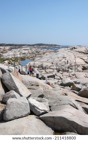 Peggy\'s Cove, August 8, 2014: People climbing around the rocks in popular touristic Peggy\'s Cove, Nova Scotia