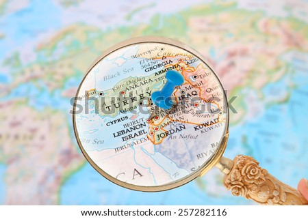 Blue tack on map of  the world with magnifying glass looking in on Beirut, Lebanon,  Middle East in Asia