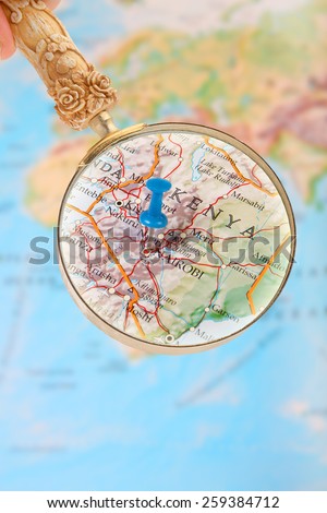 Blue tack on map of Africa with magnifying glass looking in on Nairobi, Kenya