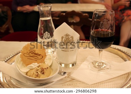 VENICE,ITALY,June,22,2015: Ice cream with buiscuit, glass of red wine, and a carafe of spring water on a platter at Cafe Florian, famous in Venice, Italy