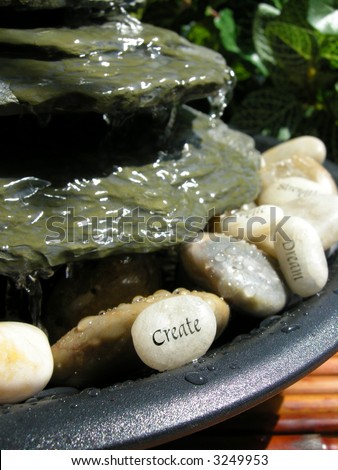 small  home zen fountain with create stone in focus