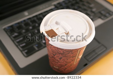 a cup of coffee to go on top of laptop