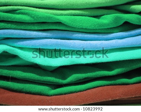 close up of a pile of colorful tshirts freshly folded from the laundry