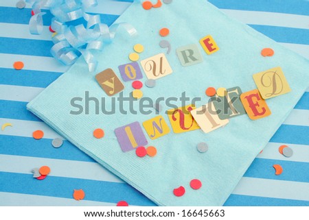 cut out letters spelling you\'re invited on baby blue napkins with curled ribbons and confetti, great for invitation cards