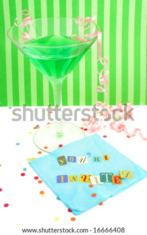 You\'re invited spelled out with cut out letters on blue napkin with blue martini with confetti and curled ribbons great for party invitations