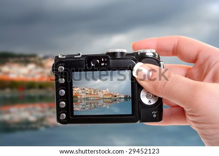 Taking a picture of Lisbon from the other side of the river in Cacilhas with reflection  and stormy clouds and sun breaking through