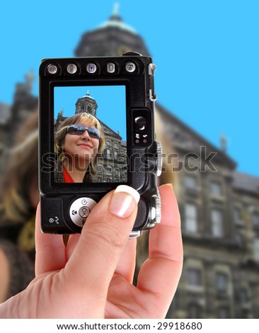 Taking a photograph of a woman in Amsterdam with a point and shoot camera, hand is finely manicured