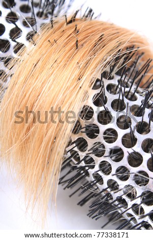 Close up of curling bristle  brush with lock of blonde hair on a white background