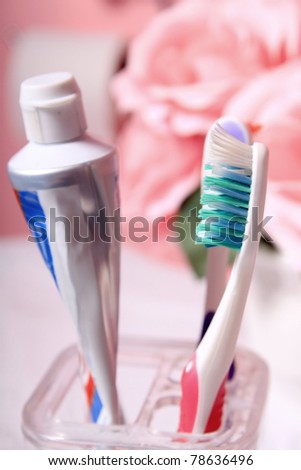 Toothpaste tube and toothbrush in pink decorated bathroom