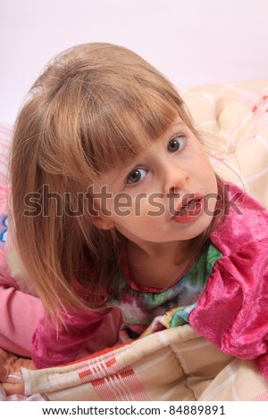 Sleepy little girl just waking up in bed cozy with blanket and messy hair