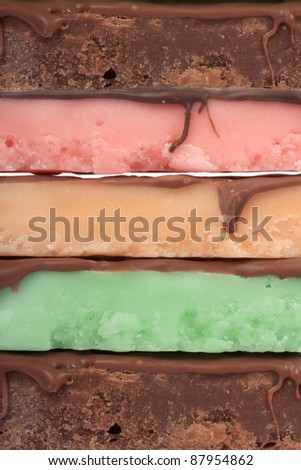 Close up of fudge bar pile in different colors and flavors covered in chocolate