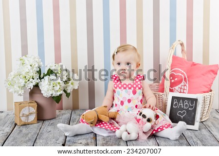 Cute girl in dress sitting on the floor among the flowers and interior items