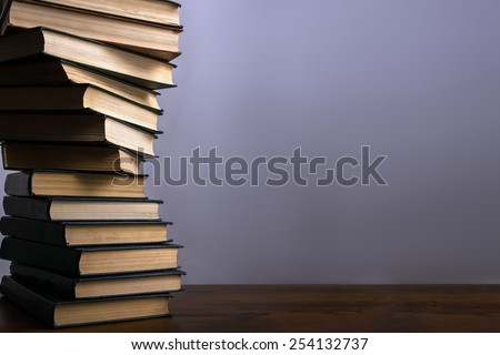 Books stacking. Back to school background. Purple wall.
