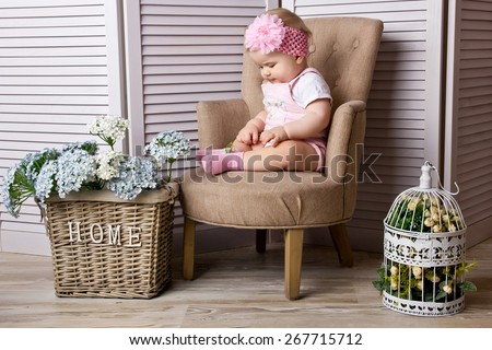 Little girl sitting on the chair at home