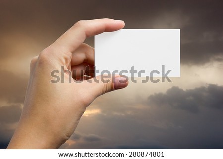 Hands holding a white business visit card, gift, ticket, pass, present closeup on sky background. Copy space