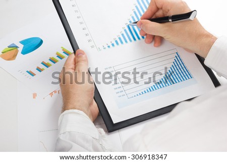 Businessman counting losses and profit working with statistics, analyzing financial the results
