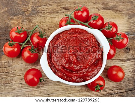 tomatoes paste with ripe tomatoes on wooden tables