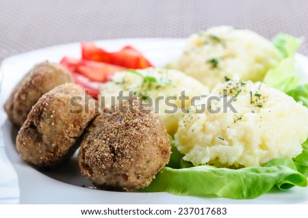 mashed potatoes on a bed of lettuce and meatball
