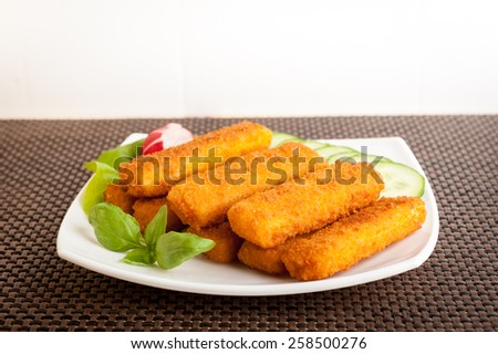 fish sticks with vegetables on a white plate