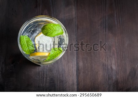 glass full of water with ice, lemon and mint