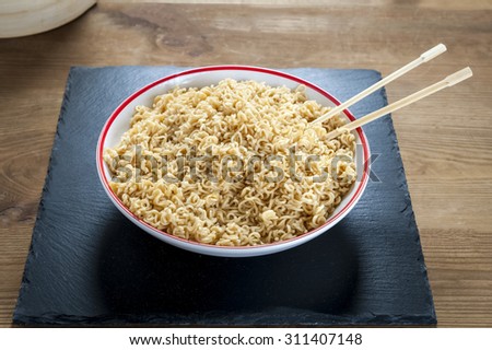 Chinese noodles in a white bowl on a stone  plate
