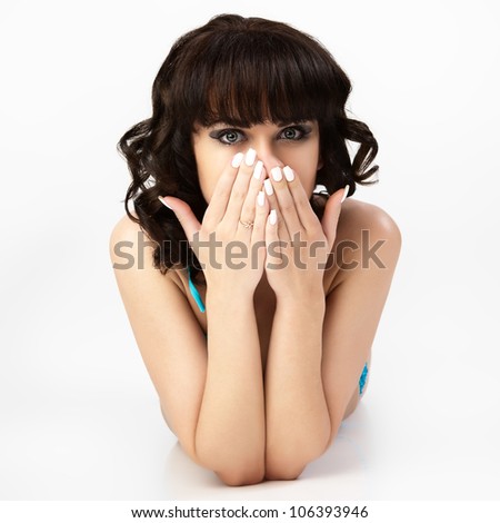 Portrait of young woman hide her face and watch through fingers.