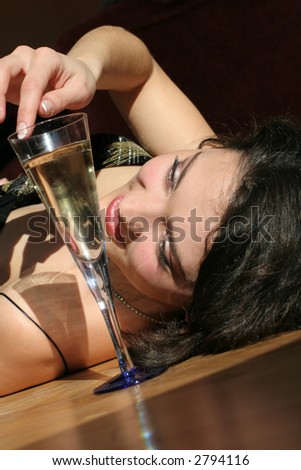 Women on wood floor with wine glass.