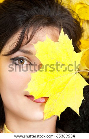 Portrait of the young women with one autumn leave.