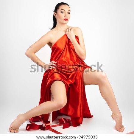 Beautiful young woman is covered with red cloth.