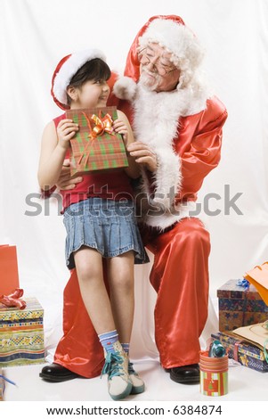little girl talking with an old santa claus
