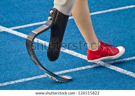 female athlete with handicap is crossing the line