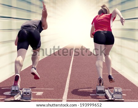 Male and female sprinter starting out of the blocks