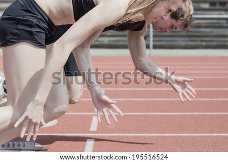 Race of male and female track and field athletes in a stadium