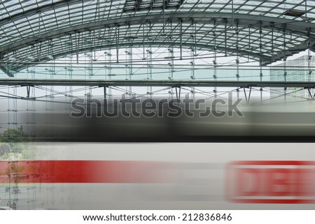 BERLIN, GERMANY- AUGUST 10, 2013: Passing ICE train with brand of the Deutsche Bahn at the main train station of Berlin, Hauptbahnhof