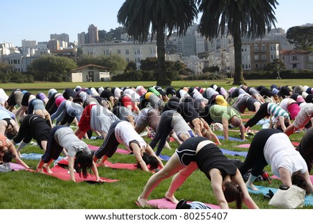 Big yoga group exercising on public ground