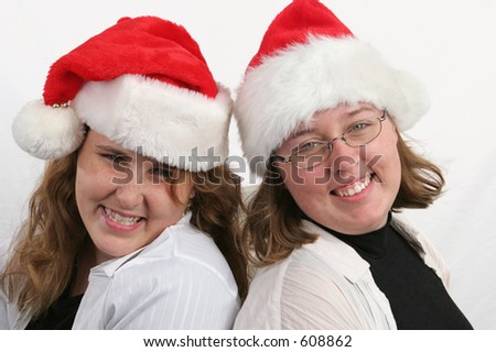 Two attractive sisters in Santa hats.