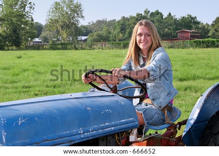 A Beautiful Farmer'S Daughter Driving A Tractor Through A Green Field ...