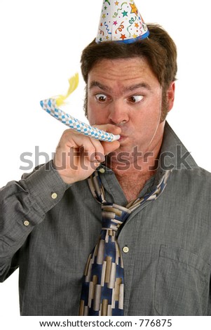 A man at a party wearing a party hat and blowing on a noisemaker.