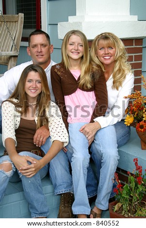 A beautiful blond family sitting together on their front porch.