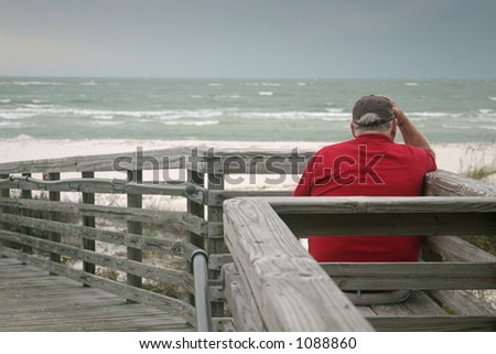 A bored old man, watching the a storm roll in over the ocean.